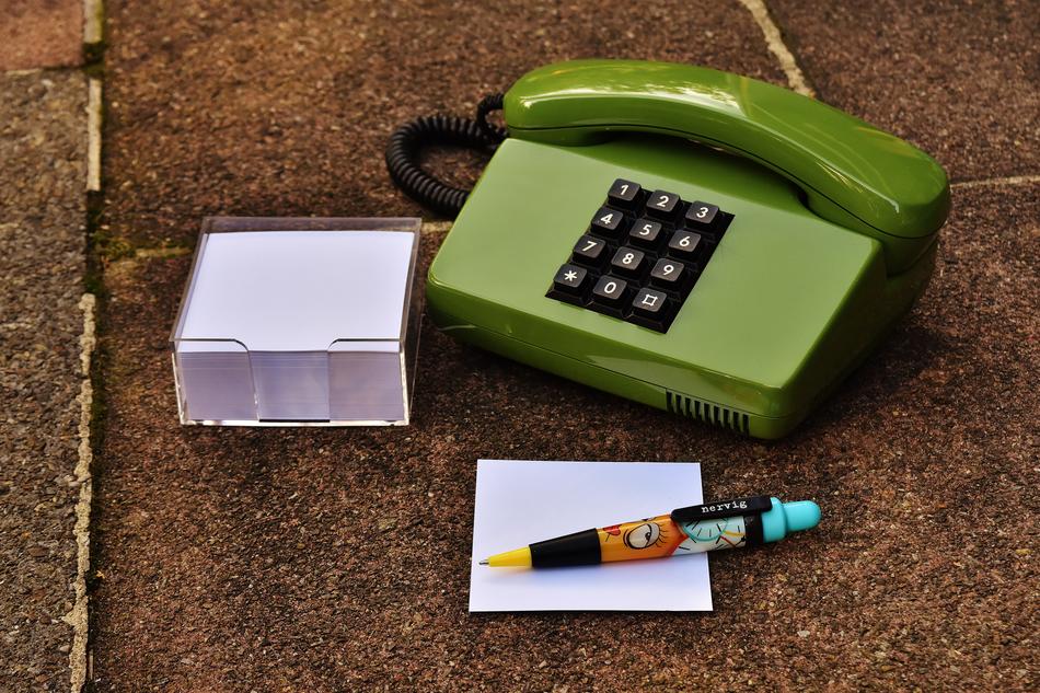 pen and leaves near the old green telephone