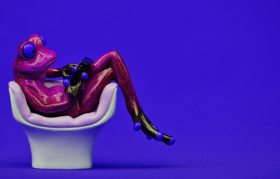 Colorful, shiny figure of the grog, on the white chair, at blue background