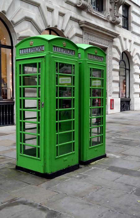green phone booths on the streets of london