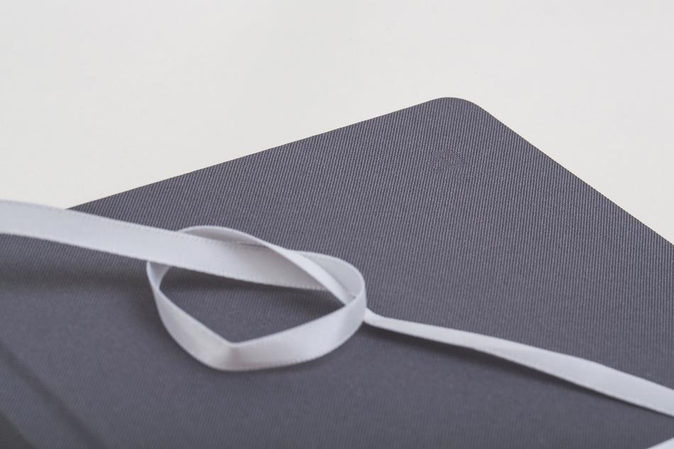Close-up of the grey book with white ribbon