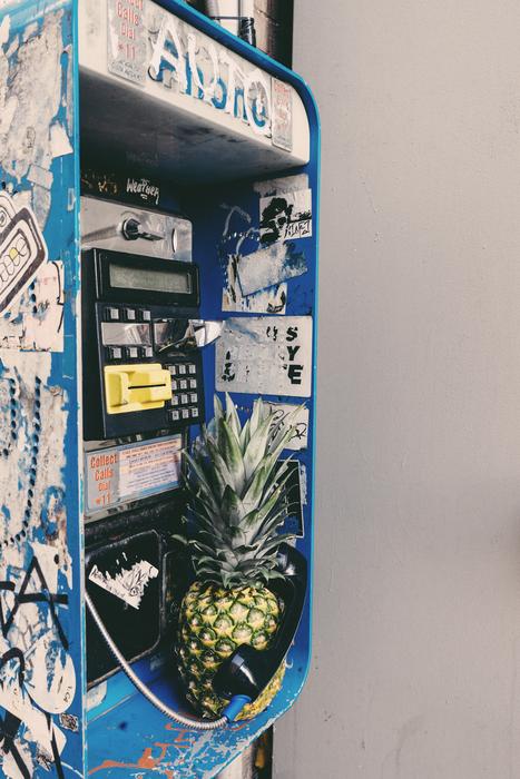 Colorful telephone box with signs and pineapple