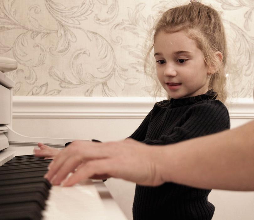girl learns to play the piano