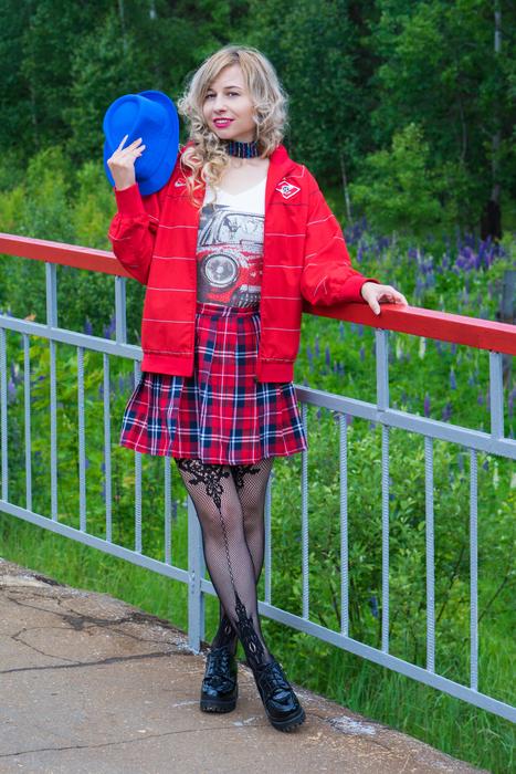 nice blonde girl in checkered skirt at railing outdoor