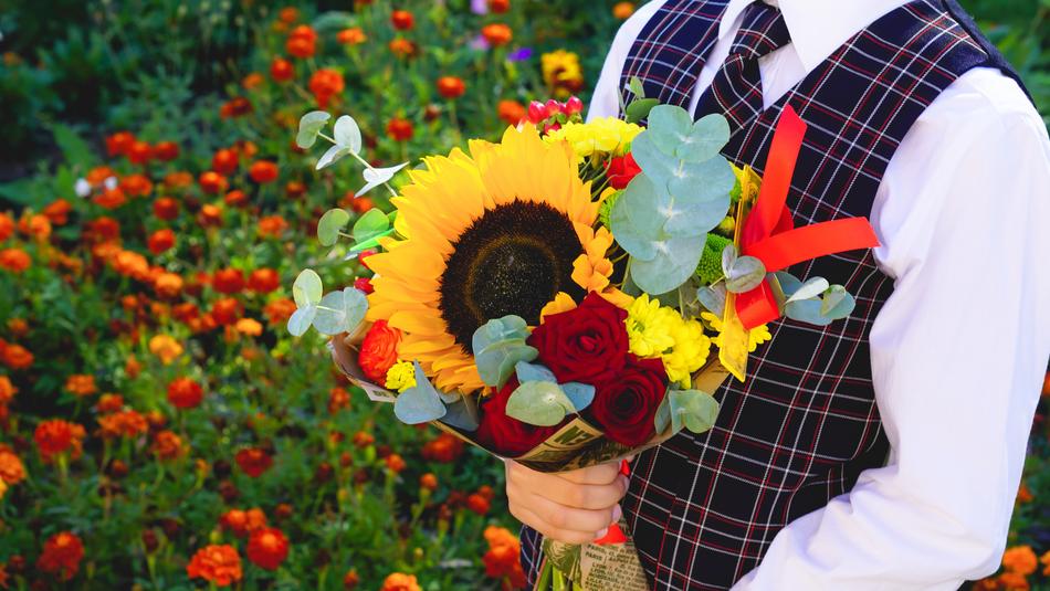 Smart Student with flowers bouquet in a hand