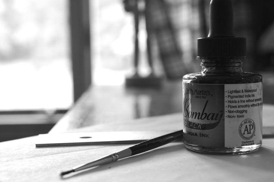 black and white photo of brush and ink on the table
