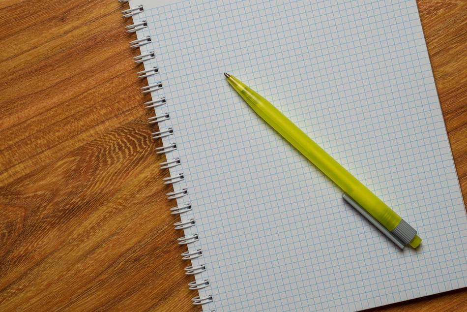 yellow ballpoint pen and notebook