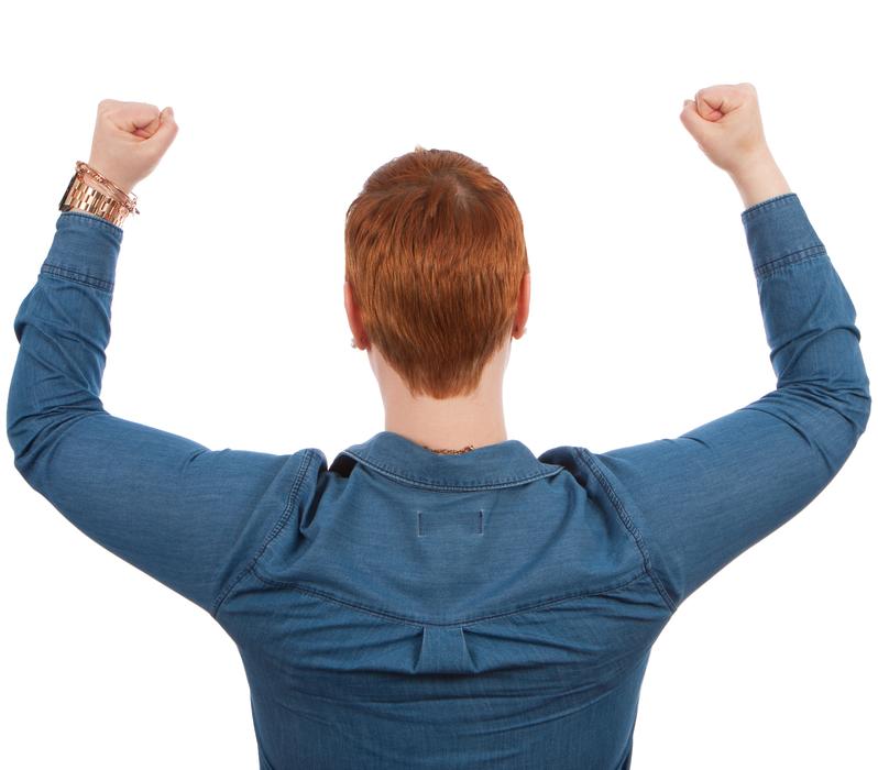 Winner, back view of redhead woman, hands up