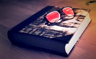 sunglasses with red lenses on the book