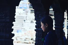Girl student, looking on the beautiful architecture in light, from the columns
