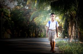 photo of a thai schoolboy against the background of palm trees