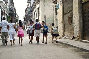 adult couple and school Children Walking on old street