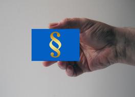 blue card with a paragraph sign in hand