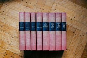 Old, red and black books, on the wooden surface