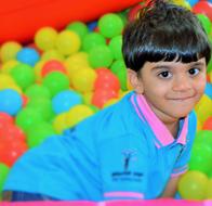 Smiling boy, among the colorful balls in the nursery