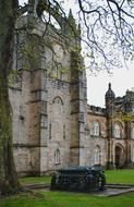 Beautiful, stone university among the green grass, under cloudy sky in Aberdeen, Scotland