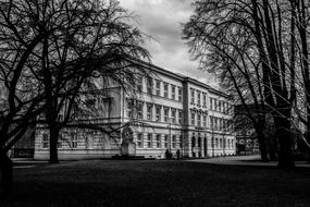 Black and white photo of the school building, among the trees in Krnov, Czech Republic