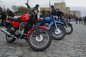 Motorcycles parked on pavement in city, low angle view
