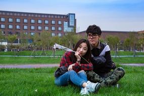 photo of asian schoolchildren in love on the lawn