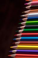 Colored Pencils in row at darkness