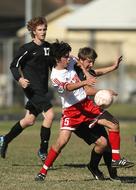 three young boys playing Soccer