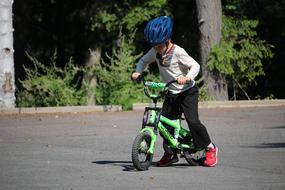 boy in helmet learns to ride a bike