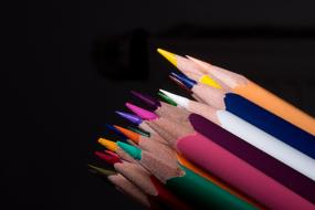 photo of a set of colored pencils on a black background