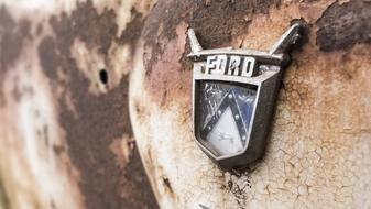 Close-up of the old Ford logo, of the rusty car