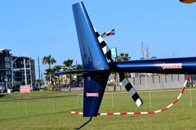 Close-up of the blue, red and white helicopter rear rotor, on the green grass field in Galveston, Texas, USA