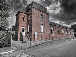 Brick school on the black and white landscape in Sains Du Nord, France