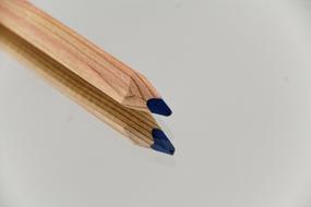 Blue wooden pencil with its reflection