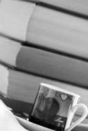 black and white photo of a cup on the background of a stack of books