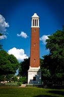 Colorful Denny Chimes in the University of Alabama, among the green trees, at blue sky, with white clouds on background