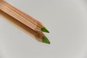 Wooden green pencil with its reflection