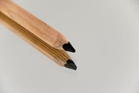 Beautiful black, wooden pencil on the shiny surface