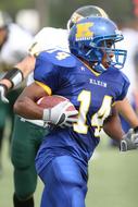 athlete with ball in american football on blurred background