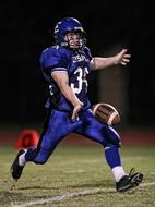 teenager with ball while playing american football