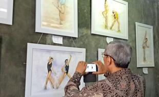 man taking photo of painting on Exhibiton