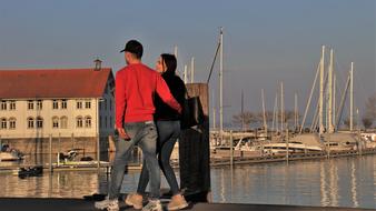 young couple in love walks in the harbor in the evening