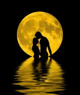 couple in love in the sea on a background of the yellow moon