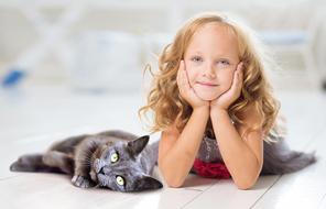 photoshoot of a young girl and a pet cat on the floor