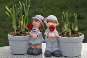 decorative children figures and plants in pots