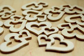 A lot of the wooden hearts on the wooden surface