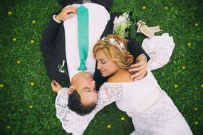 Wedding couple lays on lawn