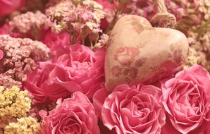 decorative heart lies on a bouquet of flowers