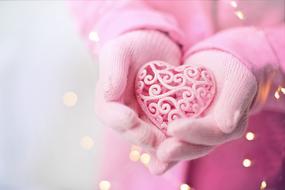 Valentineâs Day greeting, pink heart in female hands