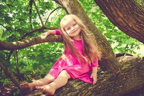 happy girl in pink dress on the tree