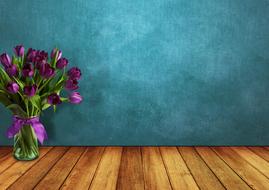 Beautiful bouquet of the purple tulips in the transparent vase, at turquoise background, on the wooden surface