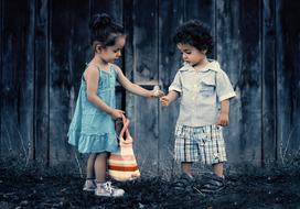 little brother and sister near the fence