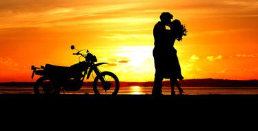 couple in love and motorcycle on a background of golden sunset