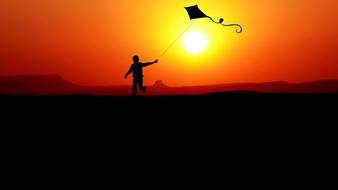 boy with a kite on a golden sunset background
